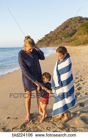 Stock Photograph - Caucasian family standing on beach. Fotosearch