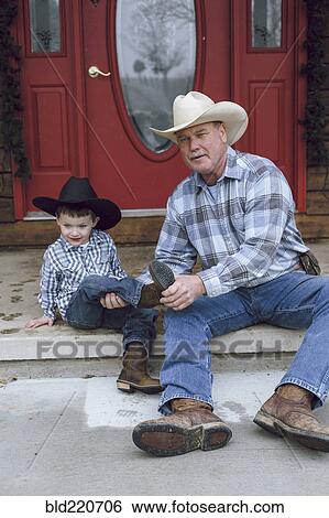 Stock Photograph - Caucasian farmer and grandson sitting on front porch. Fotosearch