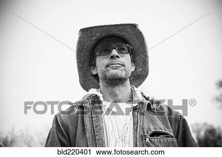 Stock Image - Caucasian farmer walking outdoors. Fotosearch