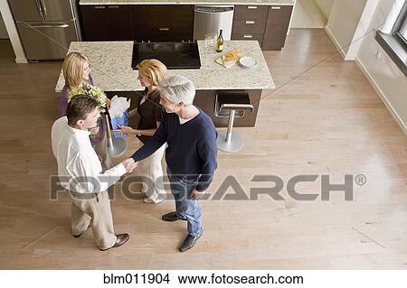 Caucasian friends talking together in modern kitchen View Large Photo Image Picture - Caucasian friends talking together in modern kitchen. Fotosearch