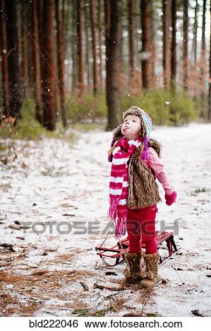 Stock Photograph - Caucasian girl catching snow on tongue. Fotosearch