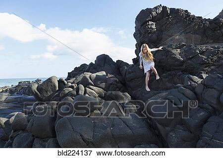 Caucasian girl climbing rocks at beach View Large Photo Image Stock Photo - Caucasian girl climbing rocks at beach. Fotosearch