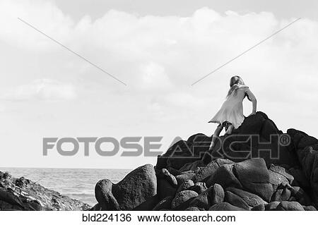 Caucasian girl climbing rocks at beach View Large Photo Image Stock Photograph - Caucasian girl climbing rocks at beach. Fotosearch