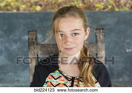 Stock Image - Caucasian girl sitting in chair. Fotosearch
