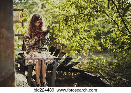 Caucasian girl sitting on table reading book View Large Photo Image Stock Photo - Caucasian girl sitting on table reading book. Fotosearch