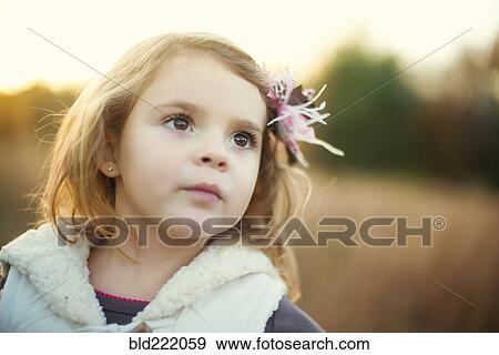 Stock Photo - Caucasian girl standing in field. Fotosearch