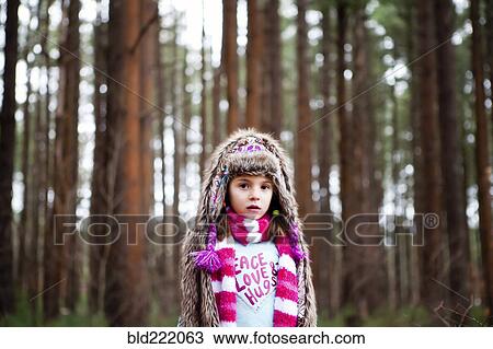 Stock Image - Caucasian girl standing in forest. Fotosearch