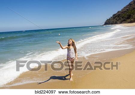 Caucasian girl tossing rock at beach View Large Photo Image Stock Photo - Caucasian girl tossing rock at beach. Fotosearch