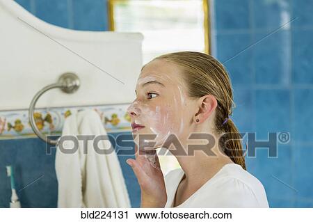 Stock Image - Caucasian girl washing face with soap. Fotosearch