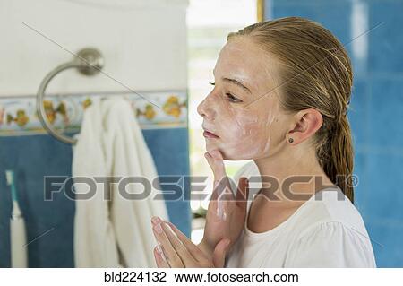 Stock Image - Caucasian girl washing face with soap. Fotosearch