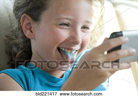 Caucasian girl with blue tongue taking selfie with cell phone View Large Photo Image Stock Photo - Caucasian girl with blue tongue taking selfie with cell phone. Fotosearch