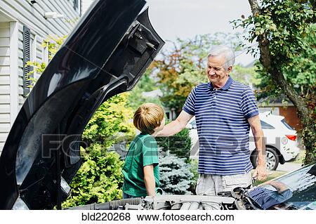 Caucasian grandfather and grandson repairing car in driveway View Large Photo Image Stock Photo - Caucasian grandfather and grandson repairing car in driveway. Fotosearch