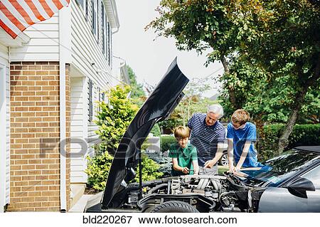Caucasian grandfather and grandsons repairing car in driveway View Large Photo Image Stock Photo - Caucasian grandfather and grandsons repairing car in driveway. Fotosearch