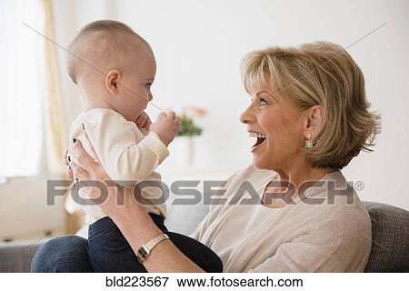 Stock Photo - Caucasian grandmother making a face at baby granddaughter. Fotosearch