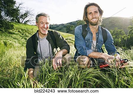 Caucasian hikers crouching in grass on mountain View Large Photo Image Stock Image - Caucasian hikers crouching in grass on mountain. Fotosearch