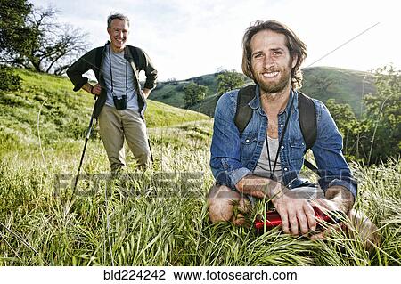 Caucasian hikers resting in grass on mountain View Large Photo Image Stock Image - Caucasian hikers resting in grass on mountain. Fotosearch
