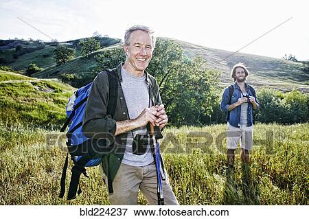 Caucasian hikers standing in grass on mountain View Large Photo Image Stock Photo - Caucasian hikers standing in grass on mountain. Fotosearch