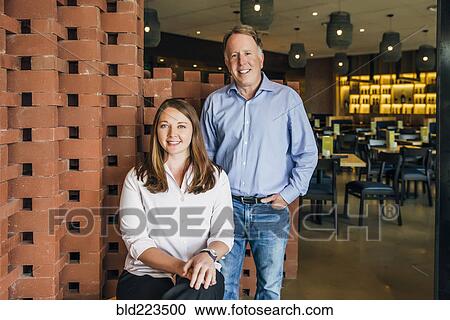 Stock Image - Caucasian man and woman smiling in restaurant. Fotosearch