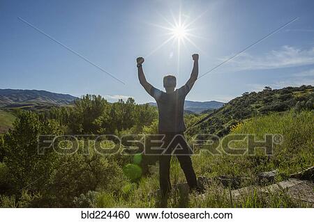 Caucasian man celebrating on mountain View Large Photo Image Stock Image - Caucasian man celebrating on mountain. Fotosearch