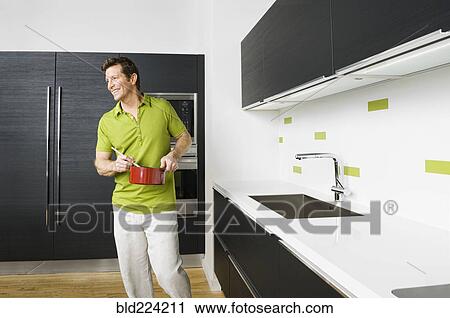 Caucasian man cooking in kitchen View Large Photo Image Stock Image - Caucasian man cooking in kitchen. Fotosearch