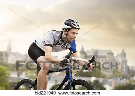 Stock Photo - Caucasian man cycling outdoors. Fotosearch