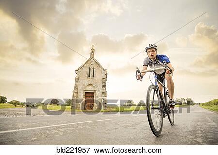 Stock Photo - Caucasian man cycling outdoors. Fotosearch