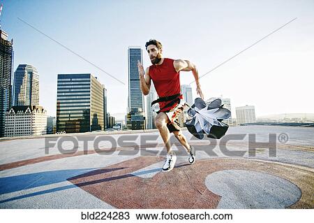 Caucasian man doing resistance training with parachute on rooftop View Large Photo Image Stock Image - Caucasian man doing resistance training with parachute on rooftop. Fotosearch