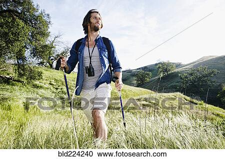 Caucasian man hiking in grass on mountain View Large Photo Image Stock Image - Caucasian man hiking in grass on mountain. Fotosearch