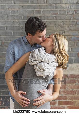 Caucasian man hugging and kissing expectant mother View Large Photo Image Stock Image - Caucasian man hugging and kissing expectant mother . Fotosearch
