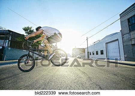 Caucasian man jumping on BMX bike on street View Large Photo Image Stock Photo - Caucasian man jumping on BMX bike on street. Fotosearch