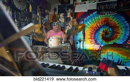 Stock Photo - Caucasian man playing drums in music studio. Fotosearch