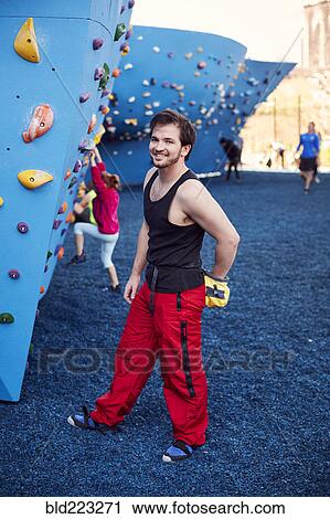 Stock Image - Caucasian man posing at outdoor climbing wall. Fotosearch