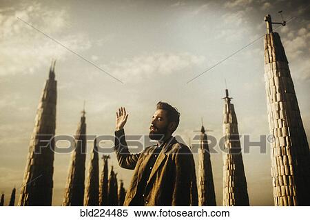 Stock Photography - Caucasian man praying near spires. Fotosearch