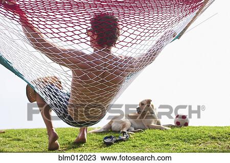 Caucasian man relaxing in hammock View Large Photo Image Stock Image - Caucasian man relaxing in hammock. Fotosearch