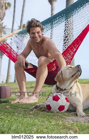 Caucasian man relaxing in hammock petting dog View Large Photo Image Stock Photography - Caucasian man relaxing in hammock petting dog. Fotosearch