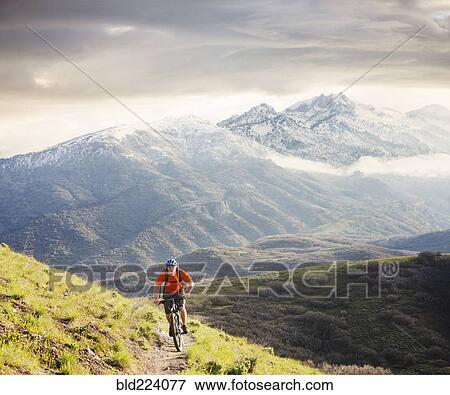 Stock Photo - Caucasian man riding mountain bike. Fotosearch