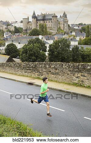 Stock Image - Caucasian man running outdoors. Fotosearch