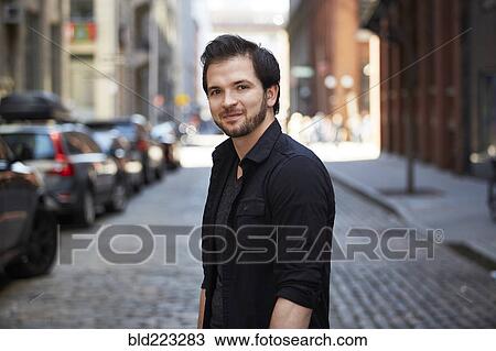 Caucasian man smiling on cobblestone city street View Large Photo Image Stock Image - Caucasian man smiling on cobblestone city street. Fotosearch