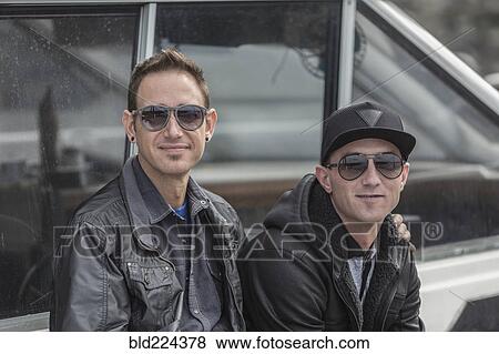Caucasian men sitting near boat View Large Photo Image Stock Photo - Caucasian men sitting near boat. Fotosearch
