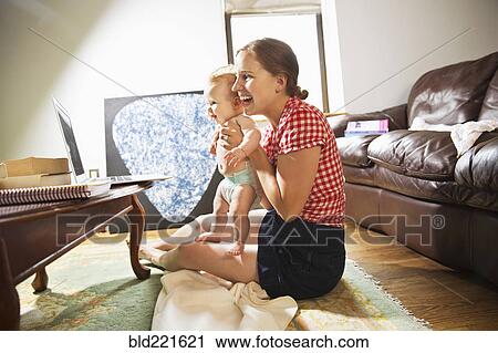 Caucasian mother and baby daughter using laptop in living room View Large Photo Image Stock Image - Caucasian mother and baby daughter using laptop in living room. Fotosearch