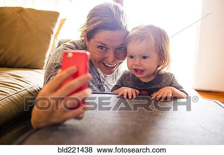 Caucasian mother and baby daughter taking selfie View Large Photo Image Stock Photo - Caucasian mother and baby daughter taking selfie. Fotosearch