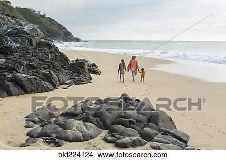 Picture - Caucasian mother and children walking on beach. Fotosearch