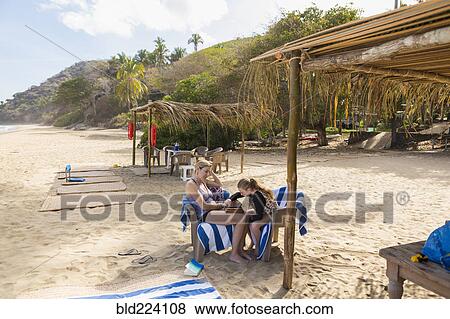Stock Photo - Caucasian mother and daughter playing backgammon at beach. Fotosearch