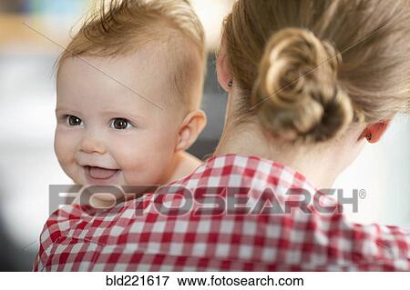 Stock Photo - Caucasian mother carrying baby daughter. Fotosearch