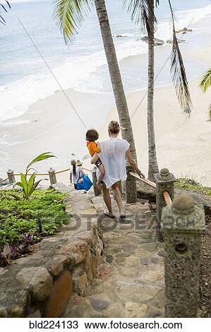 Caucasian mother carrying son descending staircase to beach View Large Photo Image Stock Image - Caucasian mother carrying son descending staircase to beach. Fotosearch