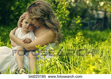 Caucasian mother holding son in grass View Large Photo Image Stock Photography - Caucasian mother holding son in grass. Fotosearch