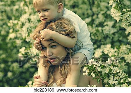 Caucasian mother holding son near flowers in tree View Large Photo Image Stock Photograph - Caucasian mother holding son near flowers in tree. Fotosearch