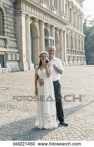 Stock Image - Caucasian newlywed couple hugging outdoors. Fotosearch
