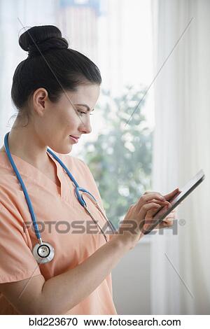 Caucasian nurse using digital tablet View Large Photo Image Stock Image - Caucasian nurse using digital tablet. Fotosearch
