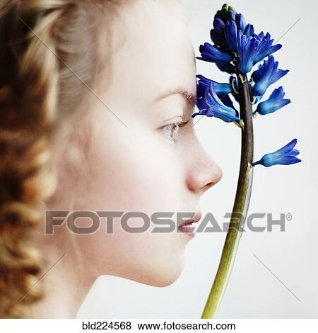 Stock Photo - Caucasian teenage girl holding flower. Fotosearch
